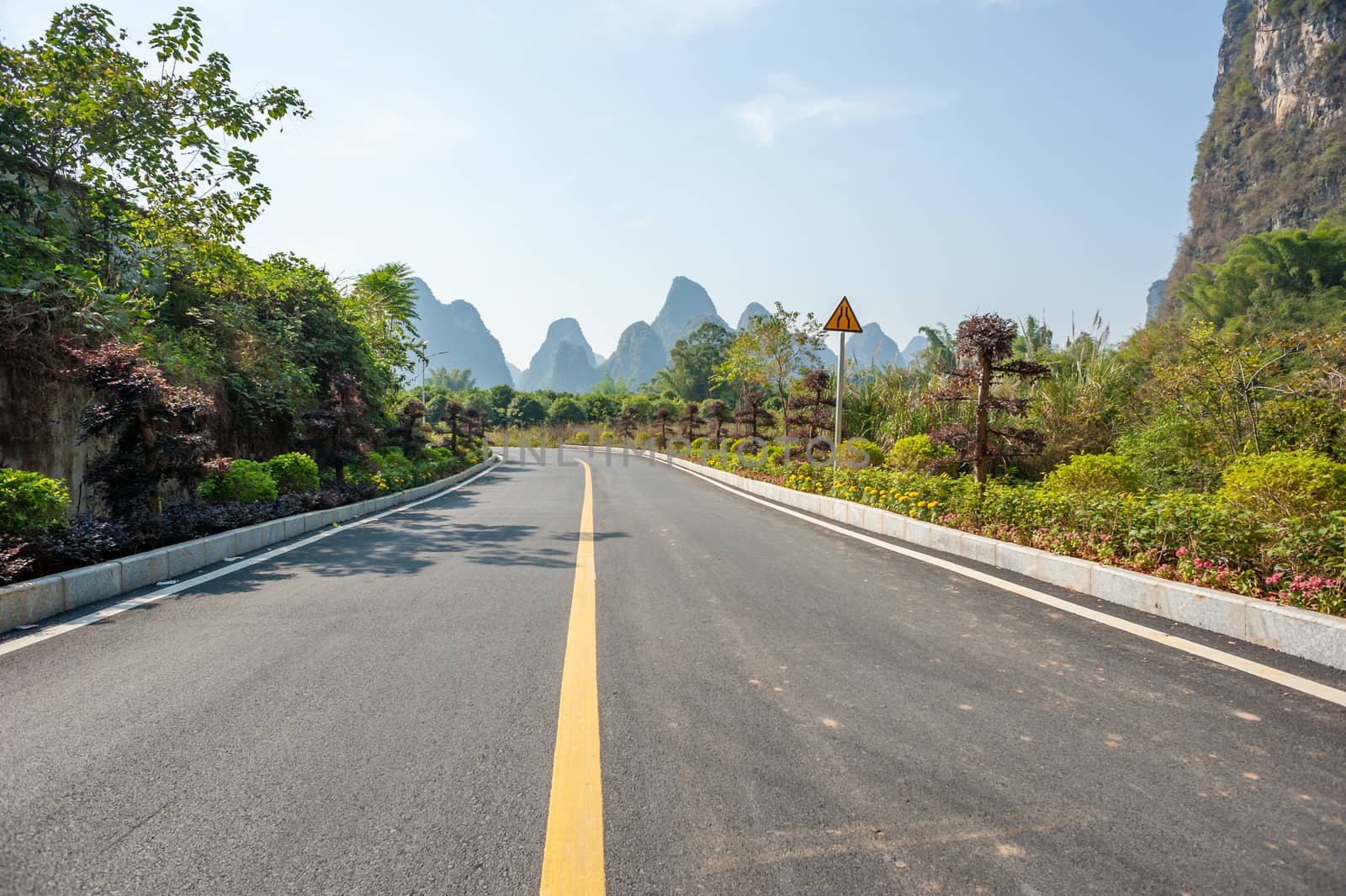 Empty road with karst hills in the background in Yangshuo, Guilin, Guangxi province, China