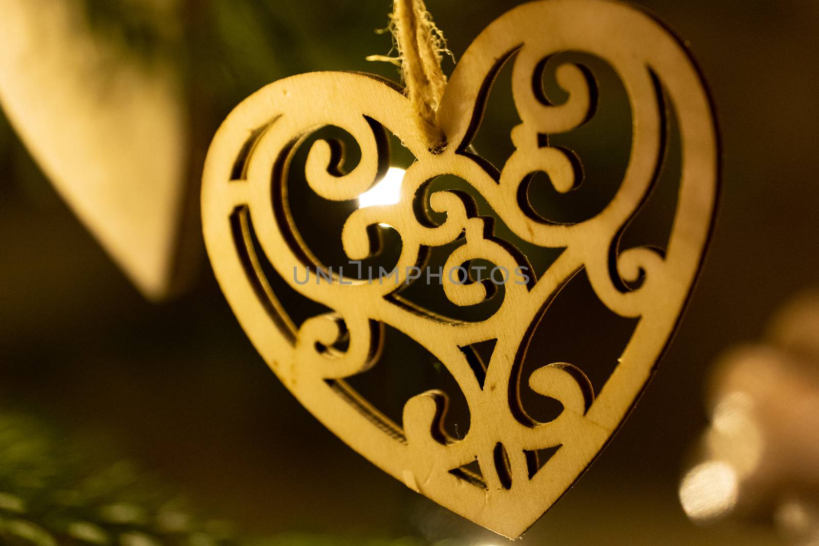 A wooden heart shaped Christmas Tree Decoration hanging from a tree