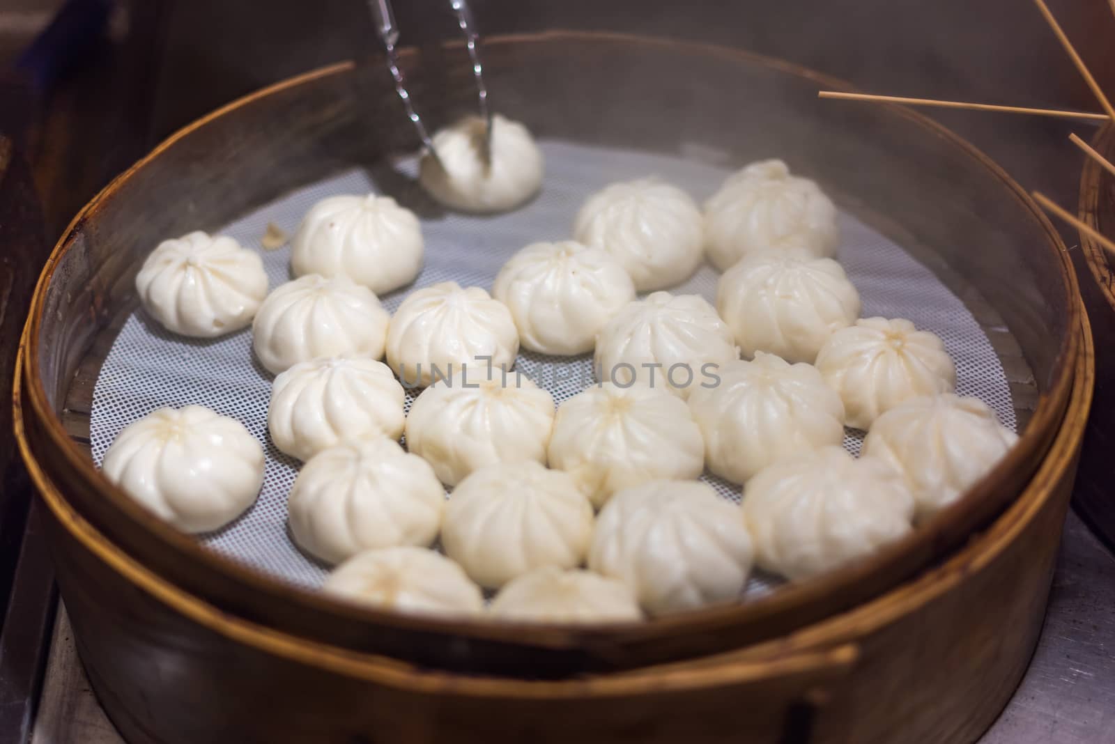 Traditional steamed buns baozi in a bamboo steamer close-up view