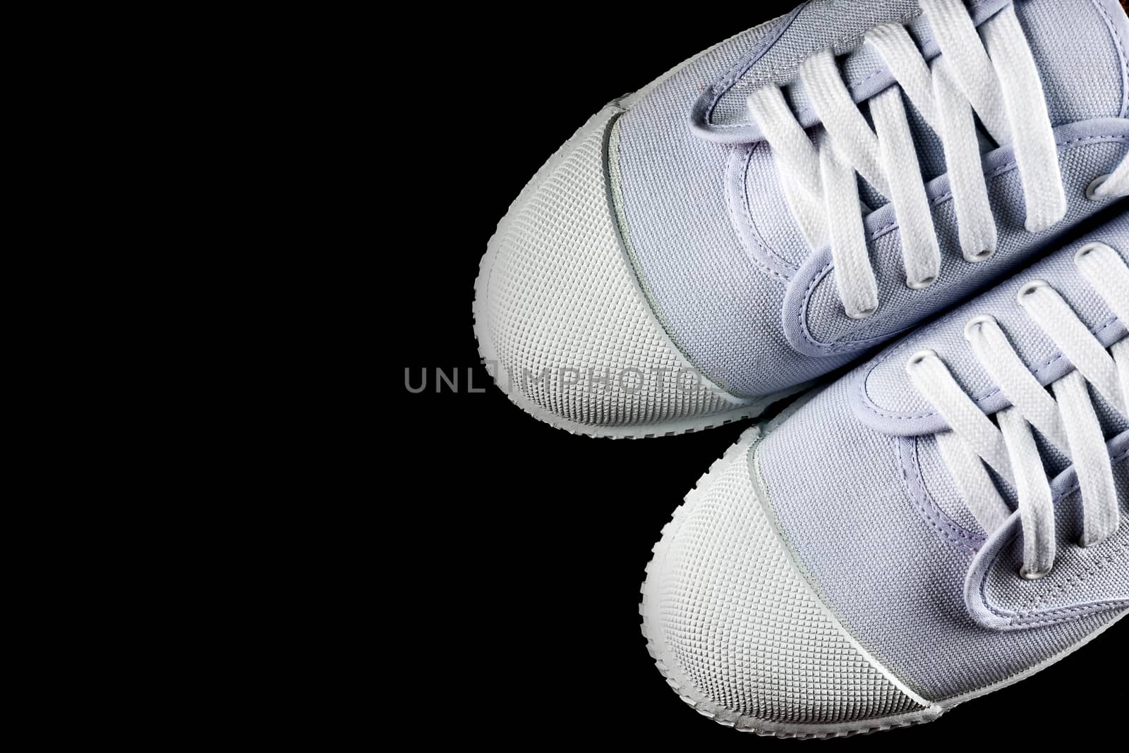 White Sneakers isolated on black background by YingTanthawarak