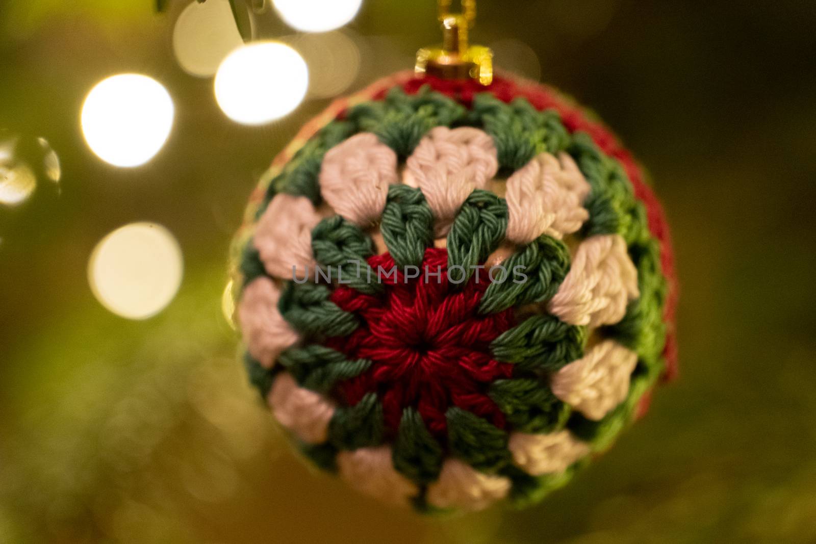 A fabric bauble shaped Christmas Tree Decoration hanging from a tree