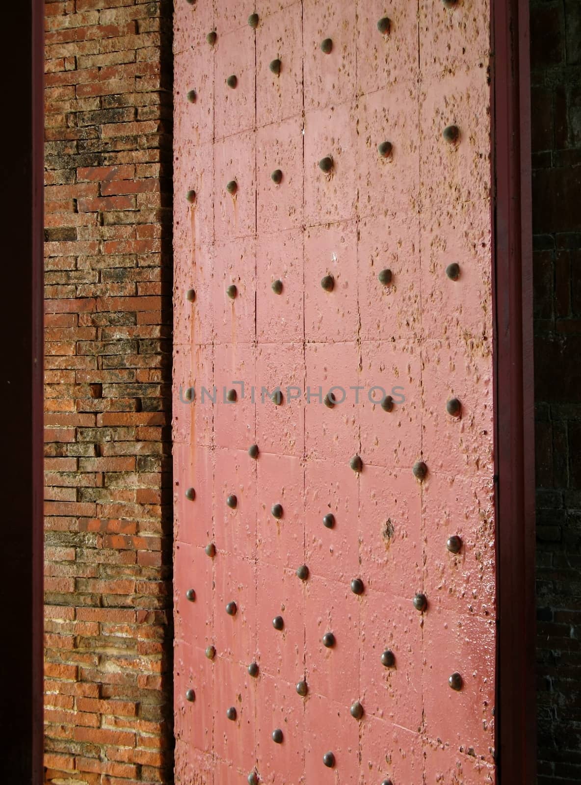 -- this door with large bronze nails guards the entrance to an old fort