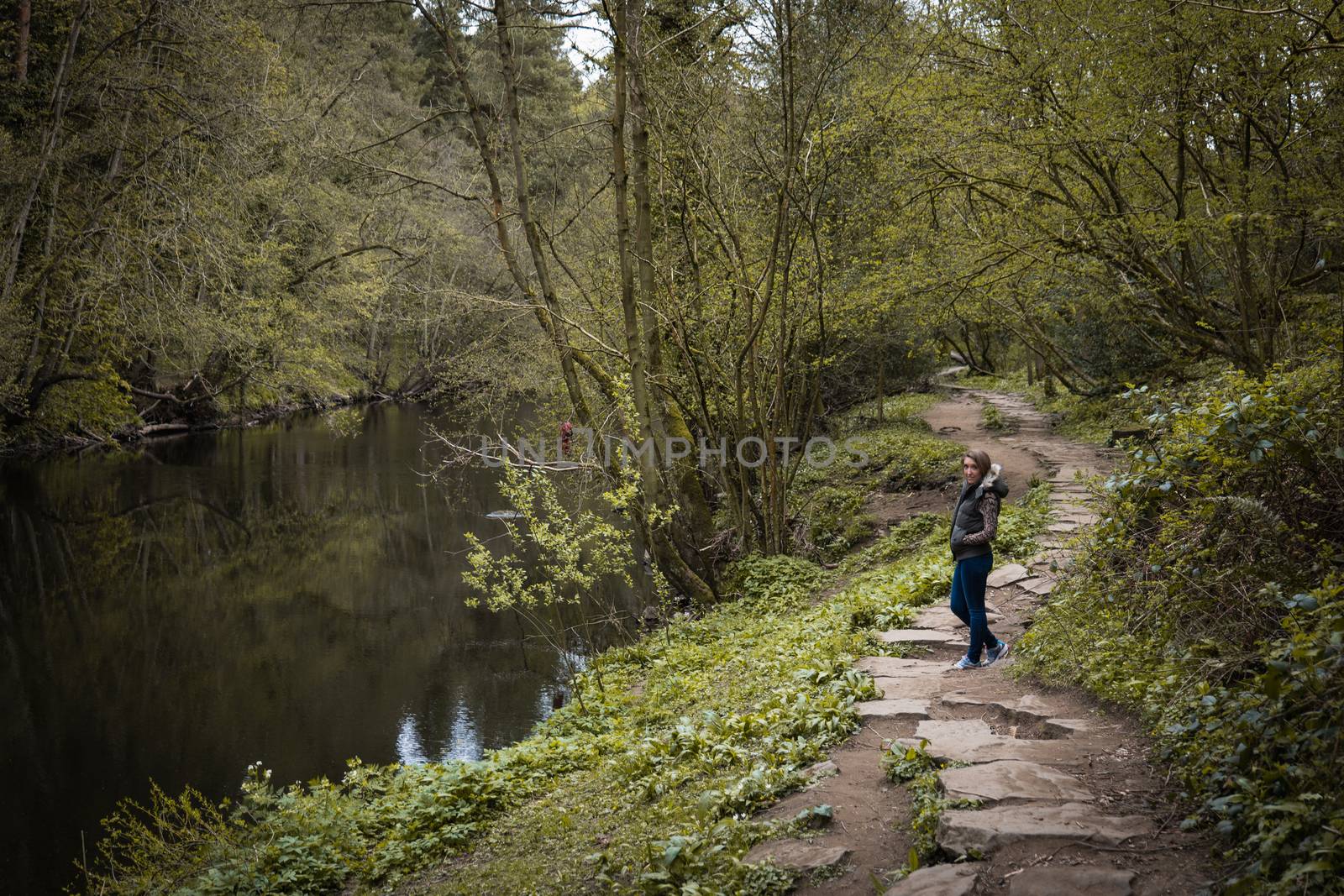 A young woman stood on a stone pavement path in the countryside