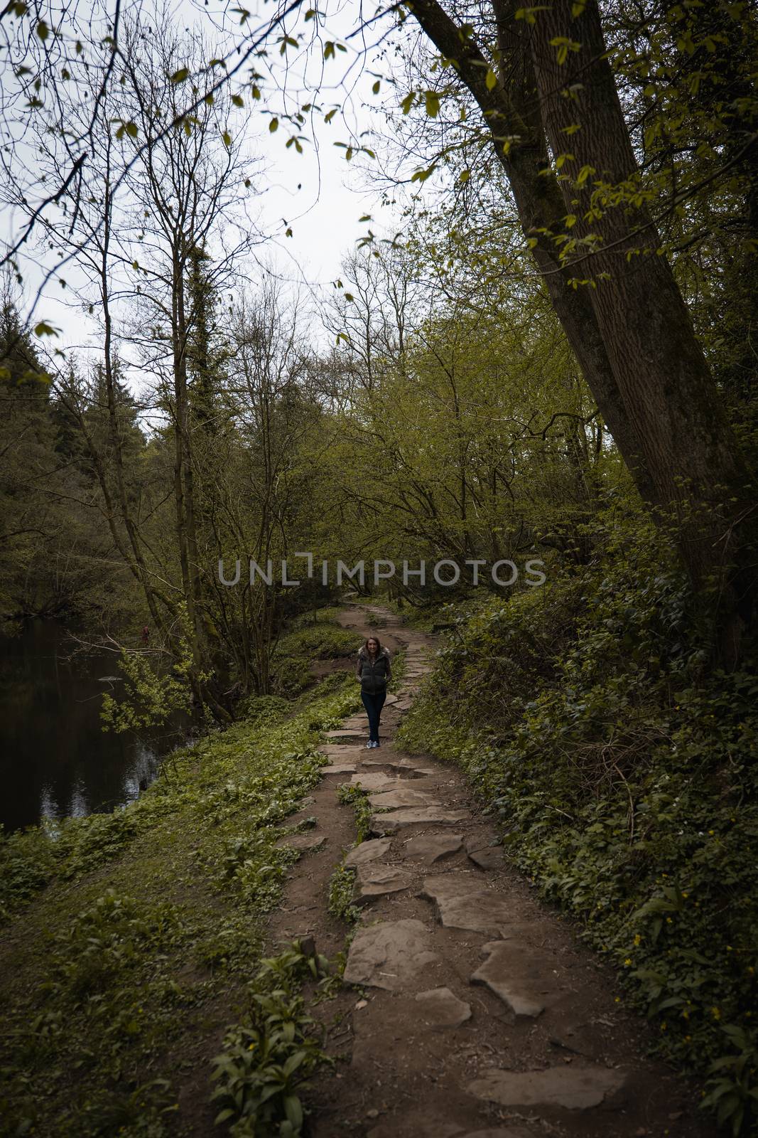 A young woman stood on a stone pavement path in the countryside