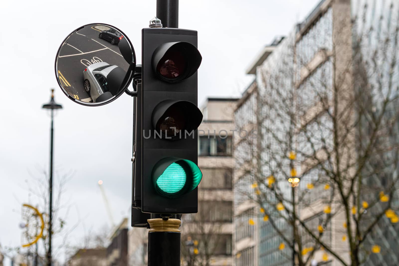 Green Traffic Light Signal and Traffic Convex Mirror with the Reflection of the vehicle