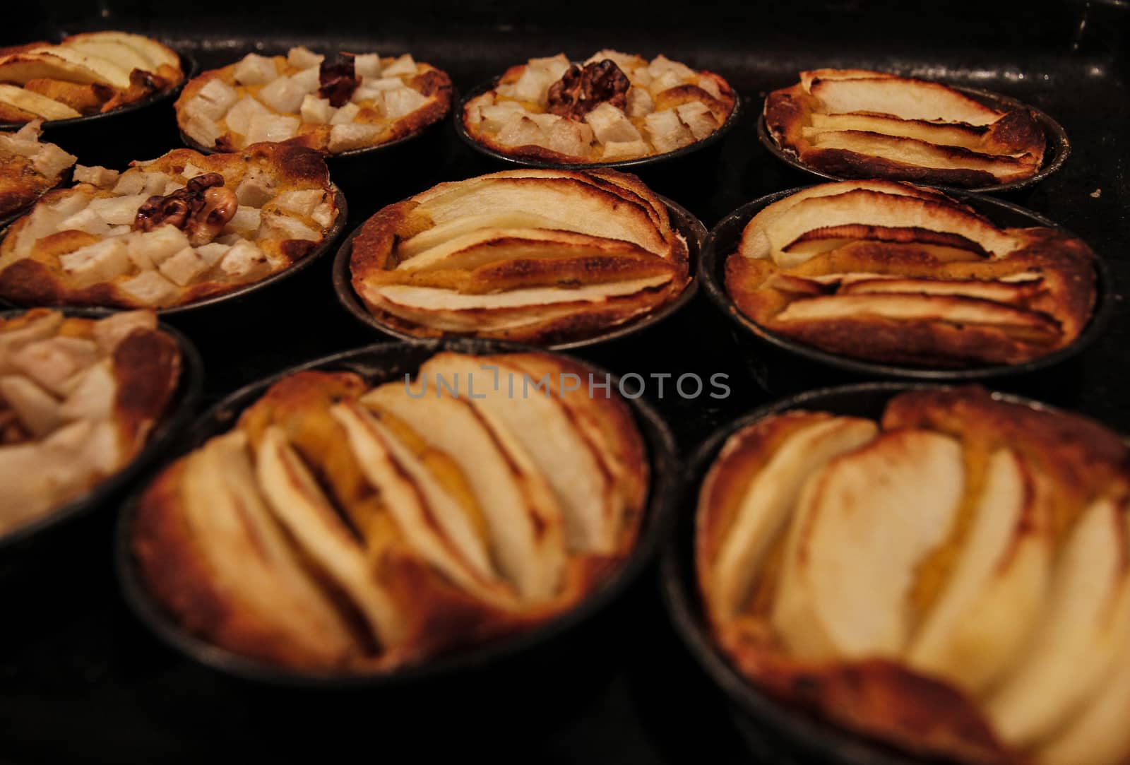 Small homemade apple pies freshly baked each in its mold by robbyfontanesi