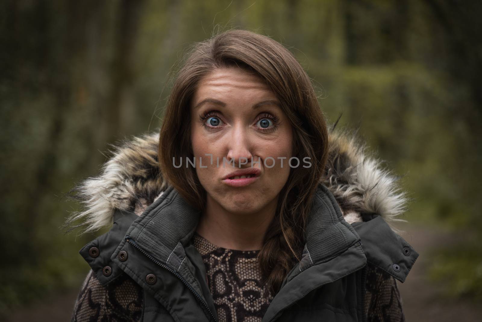 A young attractive woman pulling a silly face close up in the countryside