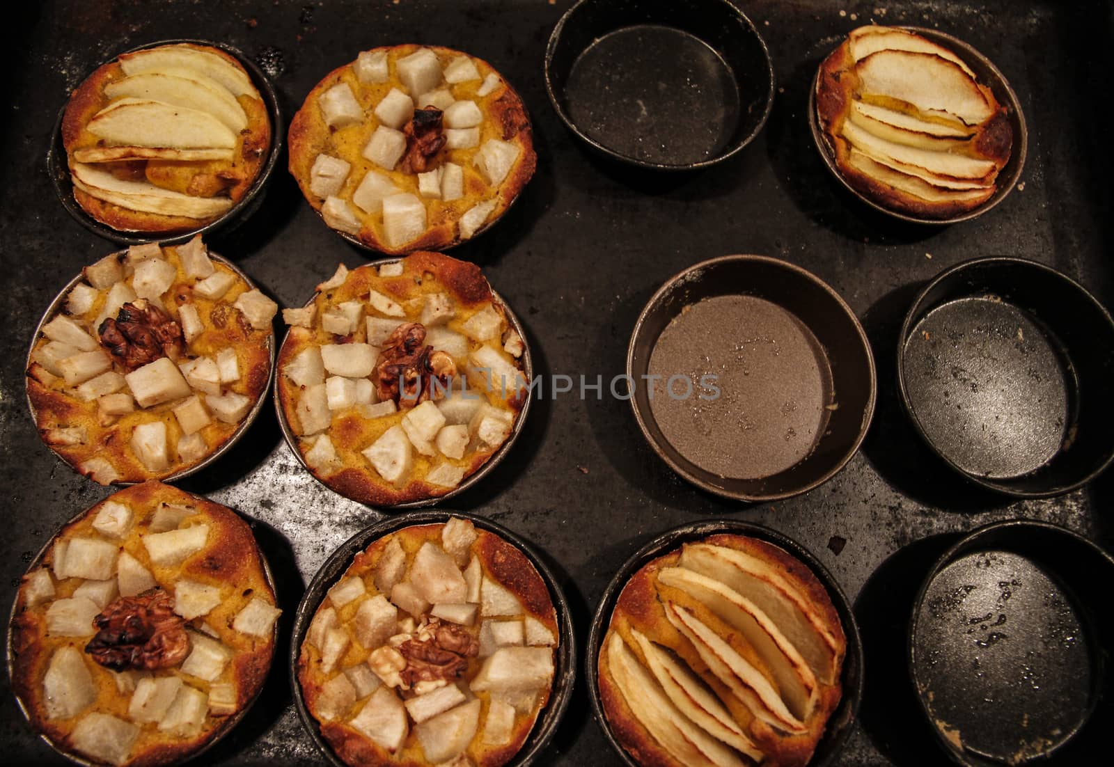 Small homemade apple pies freshly baked each in its mold by robbyfontanesi