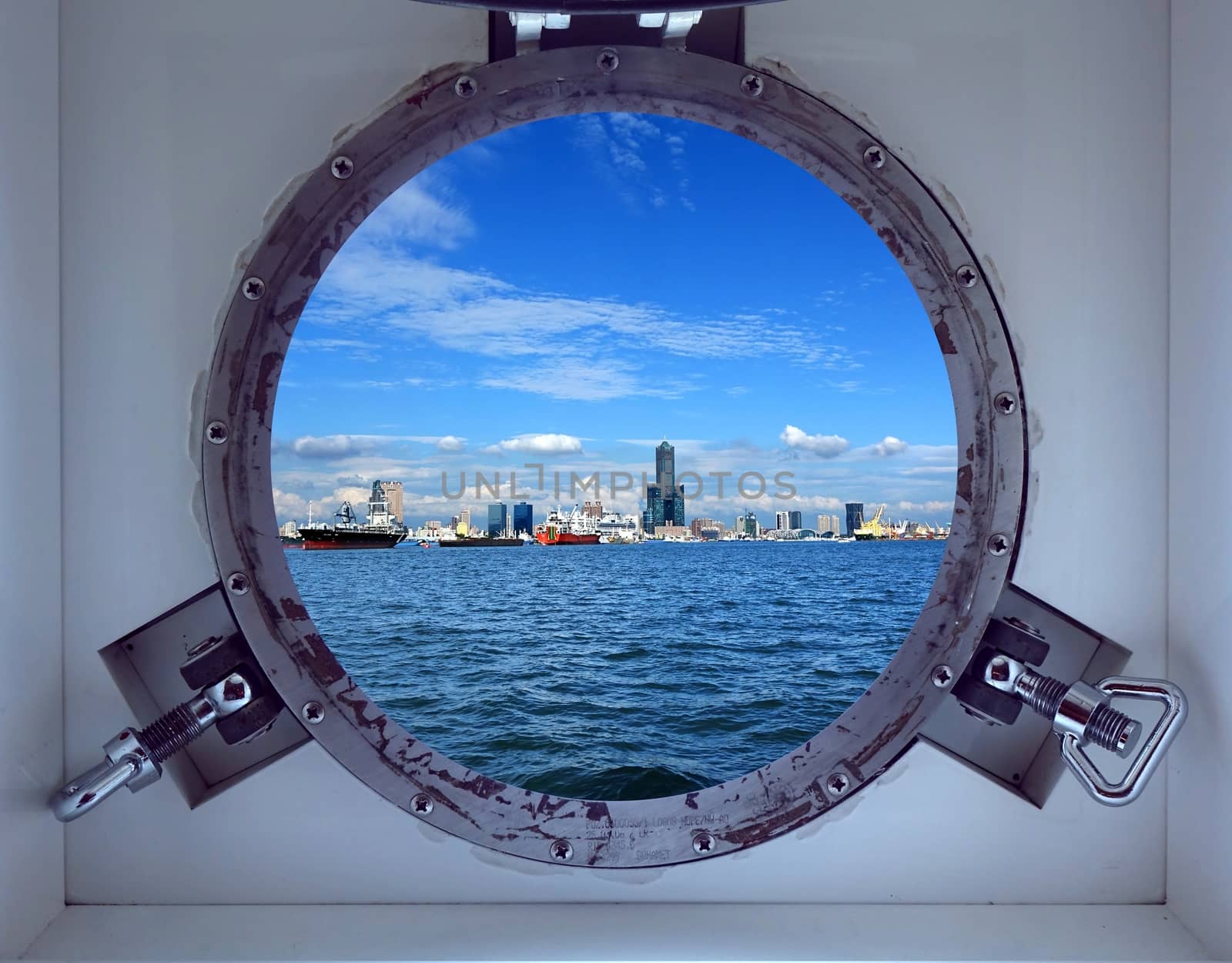 Porthole view of Kaohsiung Harbor and skyline on a bright summer day