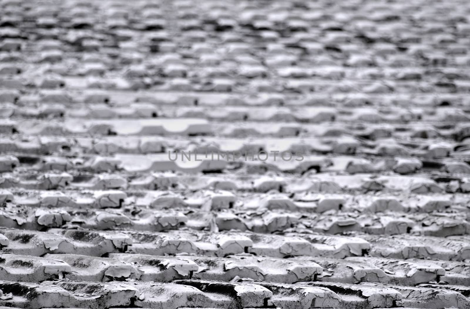 Heavily corroded roof tiles on an old building
