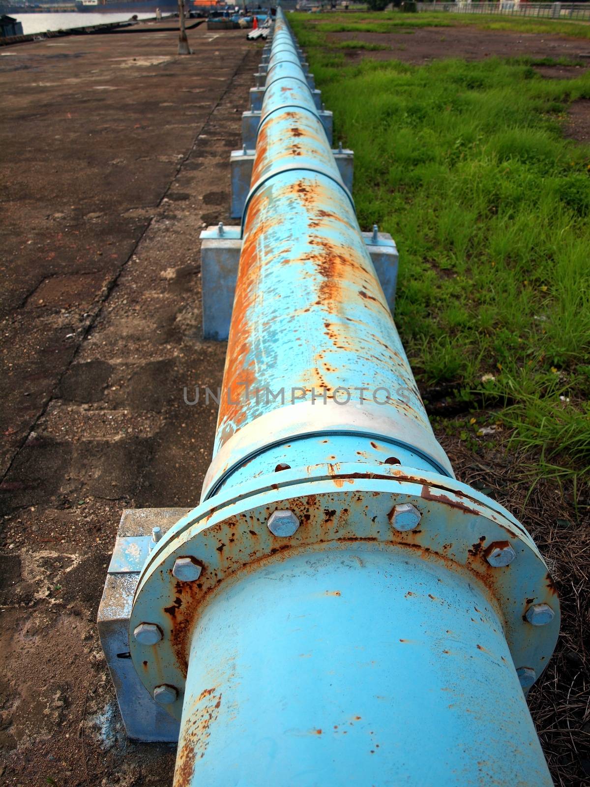 An aging pipeline with signs of corrosion stretches for into the horizon
