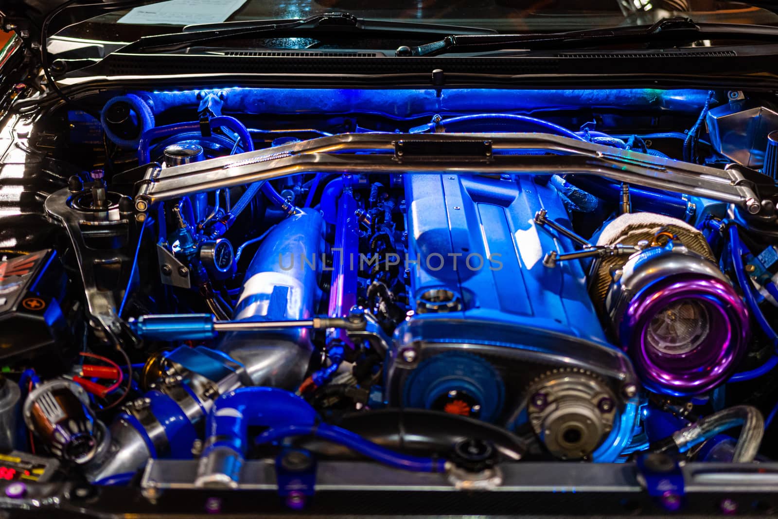 The sports car engine is illuminated with blue neon lights - image