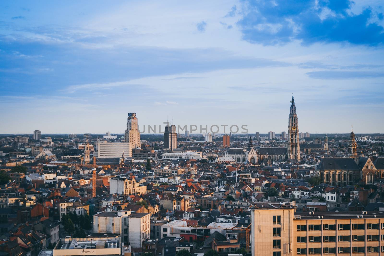 Antwerp, Belgium, June 2011: city skyline and cityscape with cathedral and boerentoren (KBC tower) on a blue sky.