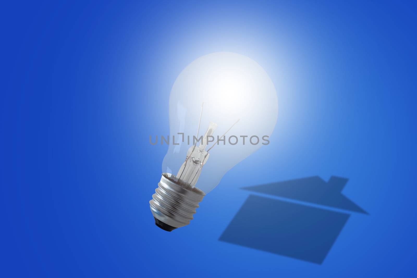 Energy concept, house shadow and light bulb on blue background, nature and ecology