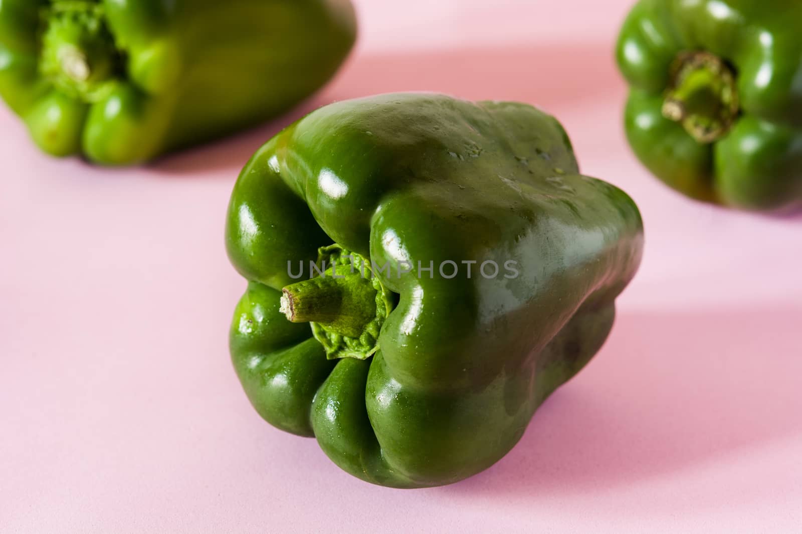 Fresh green peppers isolated on pink background