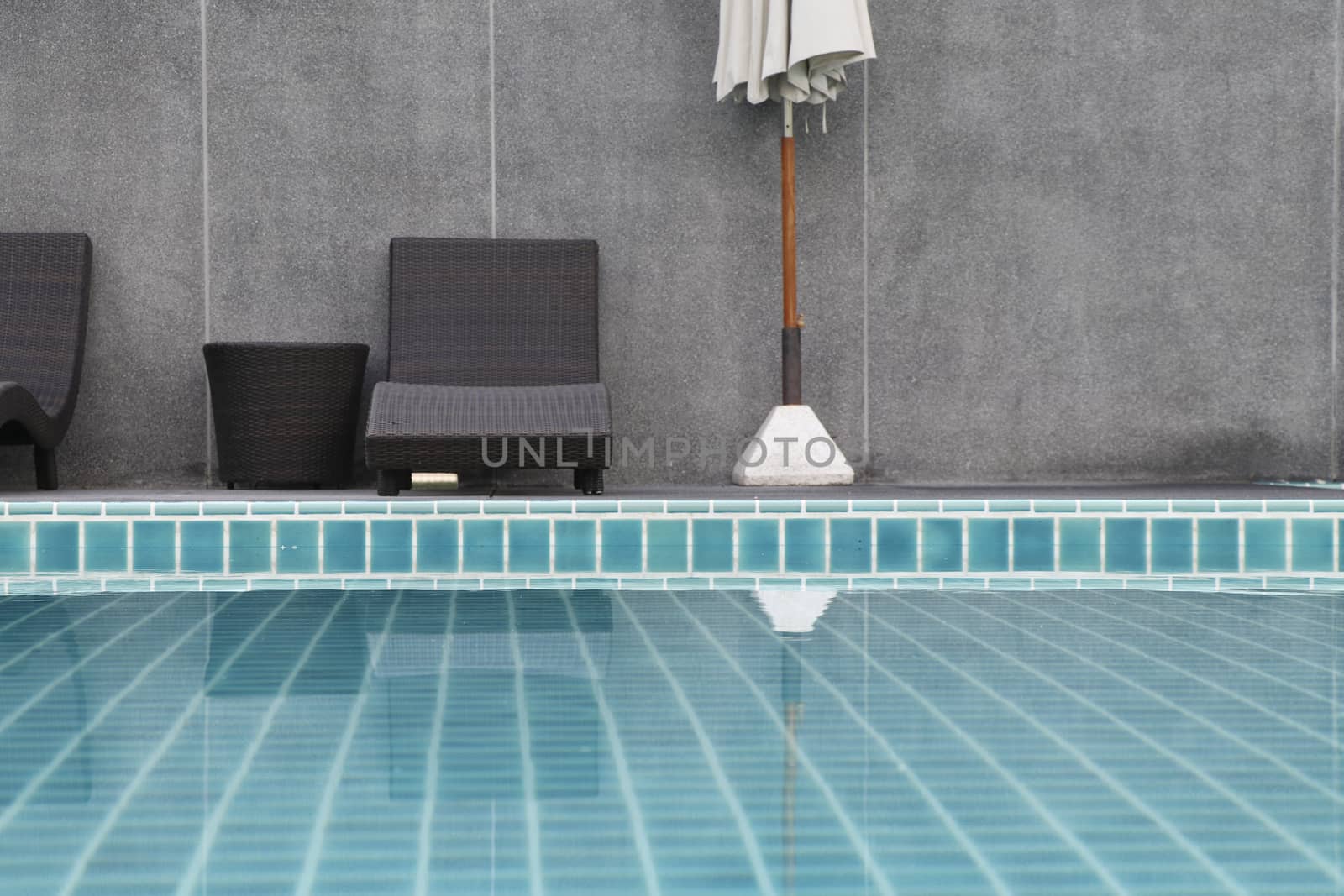 Chair and umbrella set beside the swimming pool.