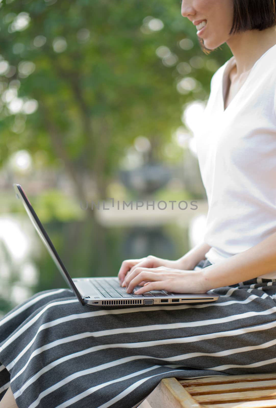 Young adult using laptop outdoors