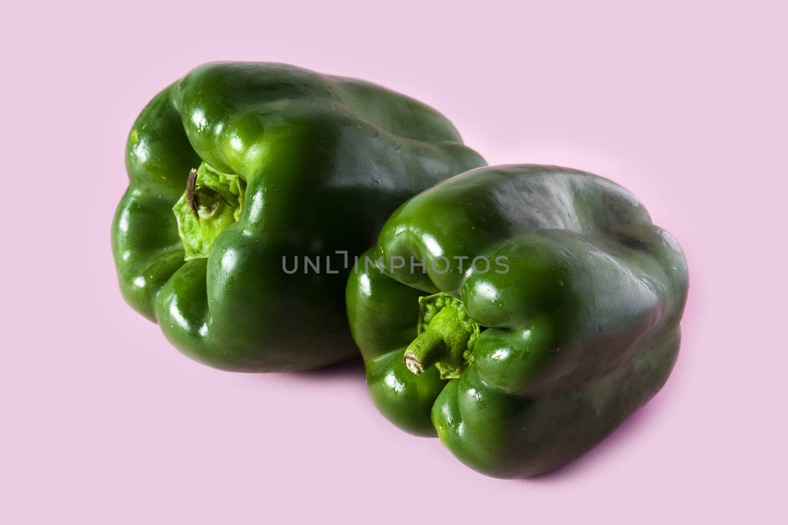Fresh green peppers isolated on pink background