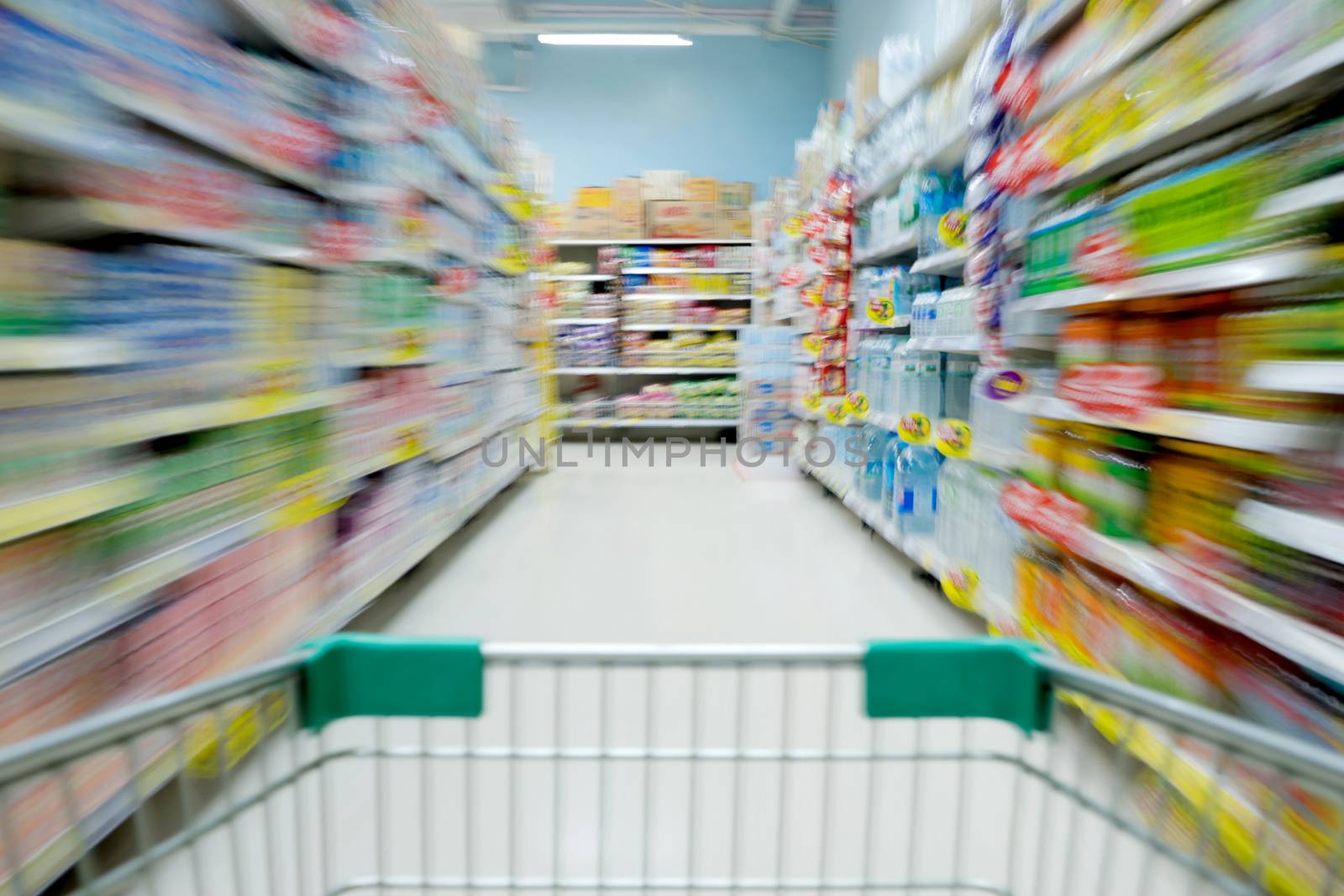 Shopping in supermarket shopping cart view with motion blur