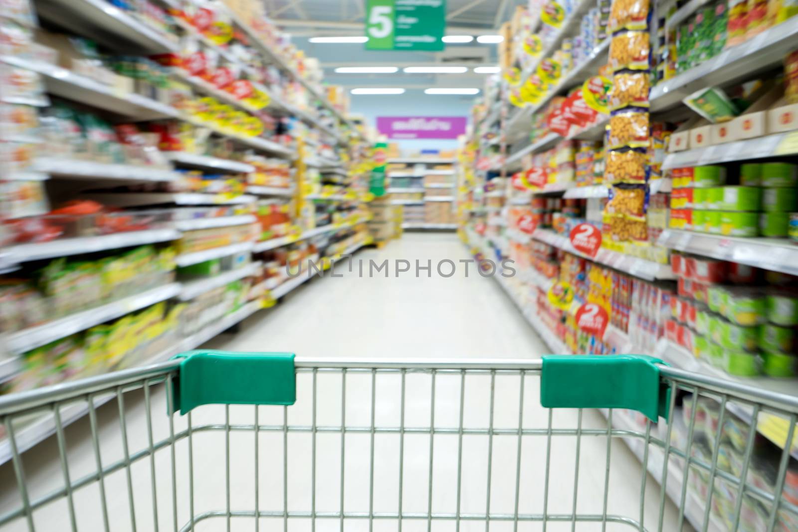Shopping in supermarket shopping cart view with motion blur