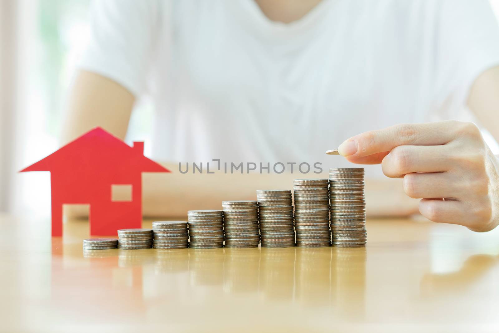 Real estate investment. House and coins on table.