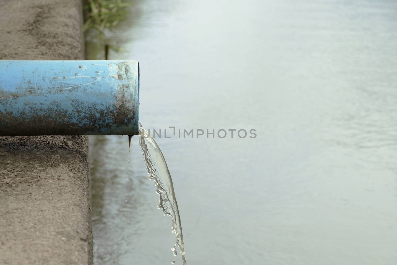 The sewer that water is flowing from the end of the pipe. Water is flowing from the pipe.