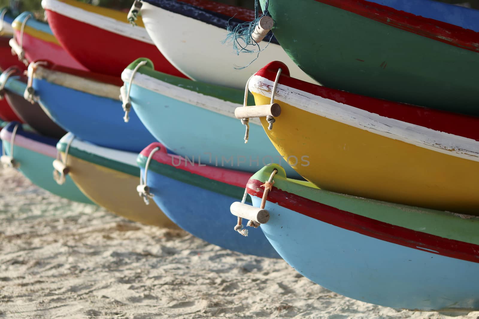 Colorful boats park on the beach. The ship is stacked on the beach. by Eungsuwat