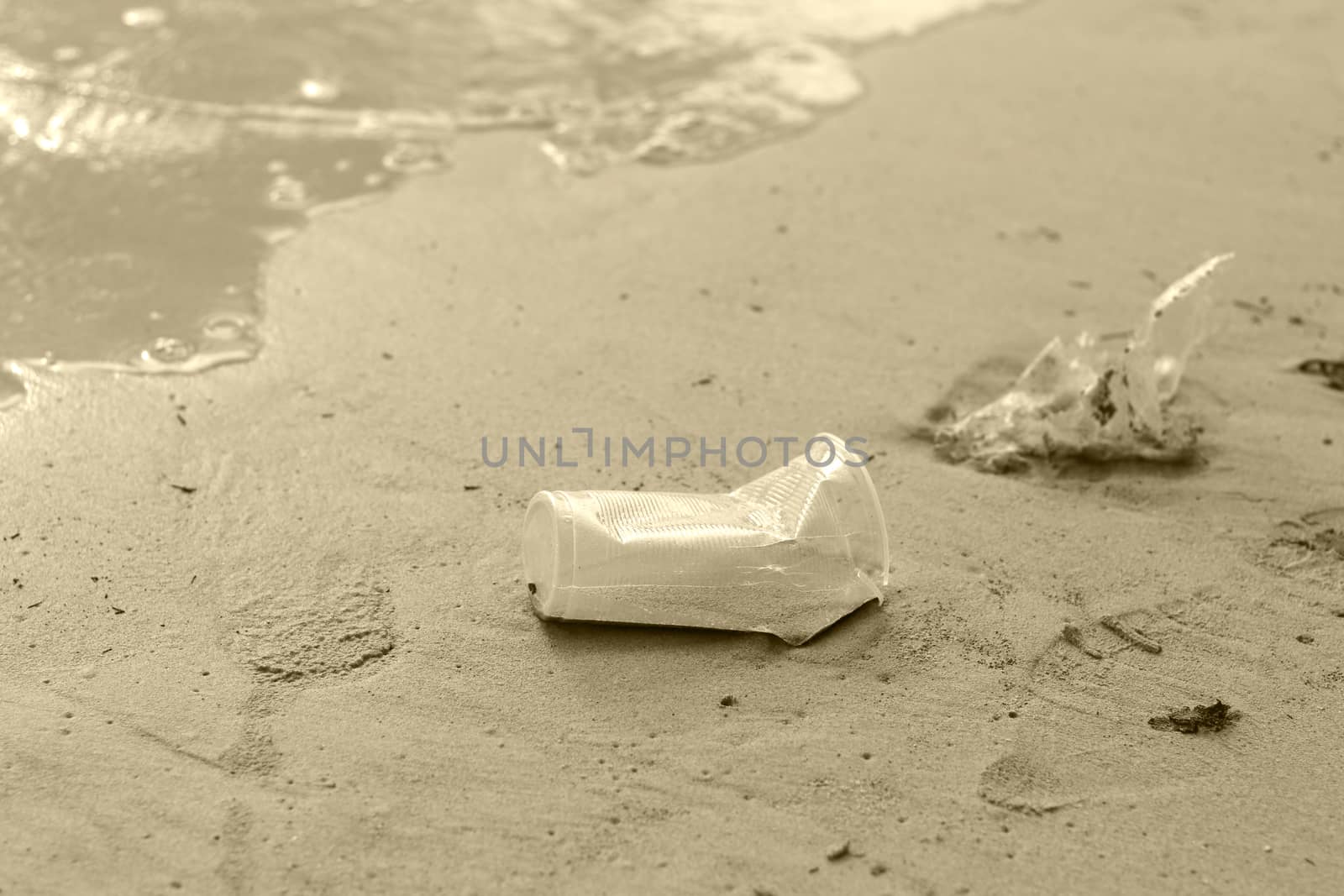 Plastic glass waste is placed at the edge of the beach. Beach garbage