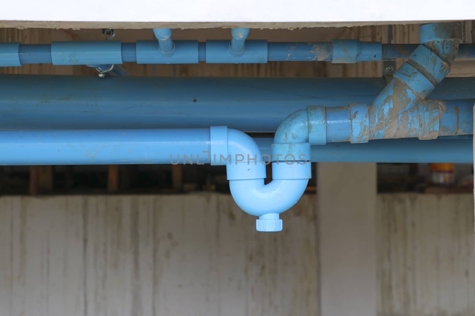 Blue P-trap pvc for reverse odor protection. Blue sanitary P-trap installed at site construction.