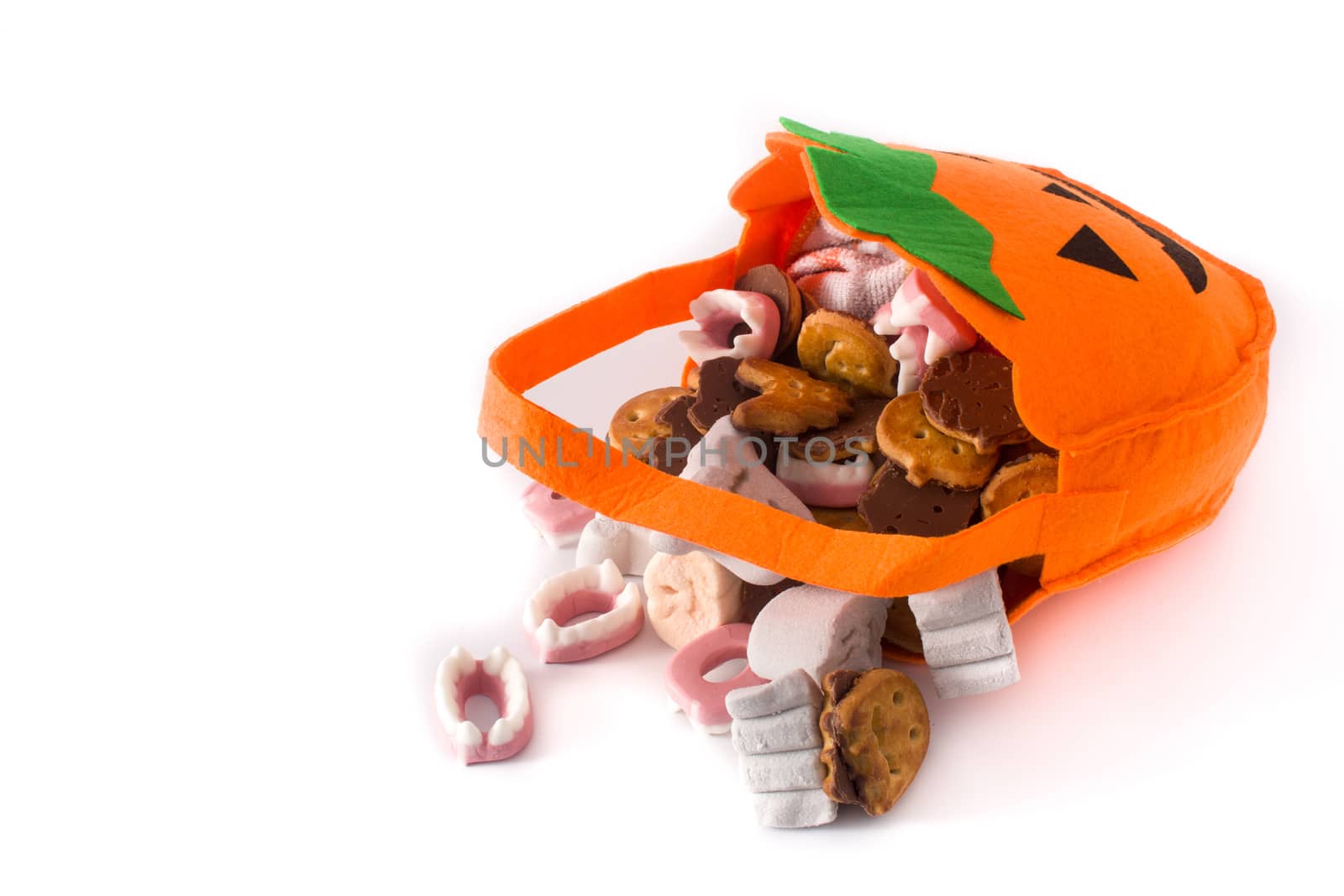 Halloween pumpkin bag with candies inside isolated on white background