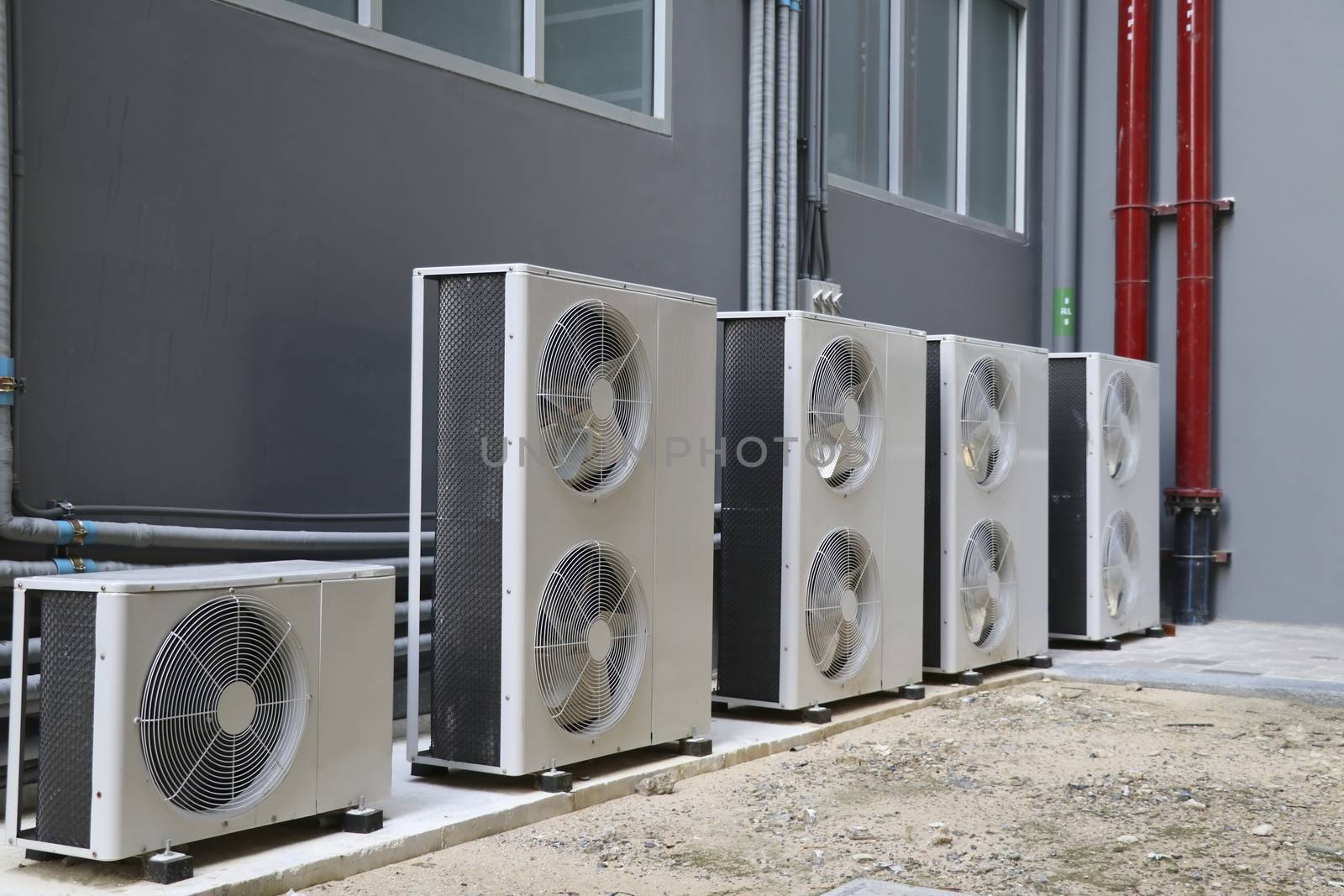 Condensing unit of air conditioning systems. Condensing unit installed in a row outside the building.