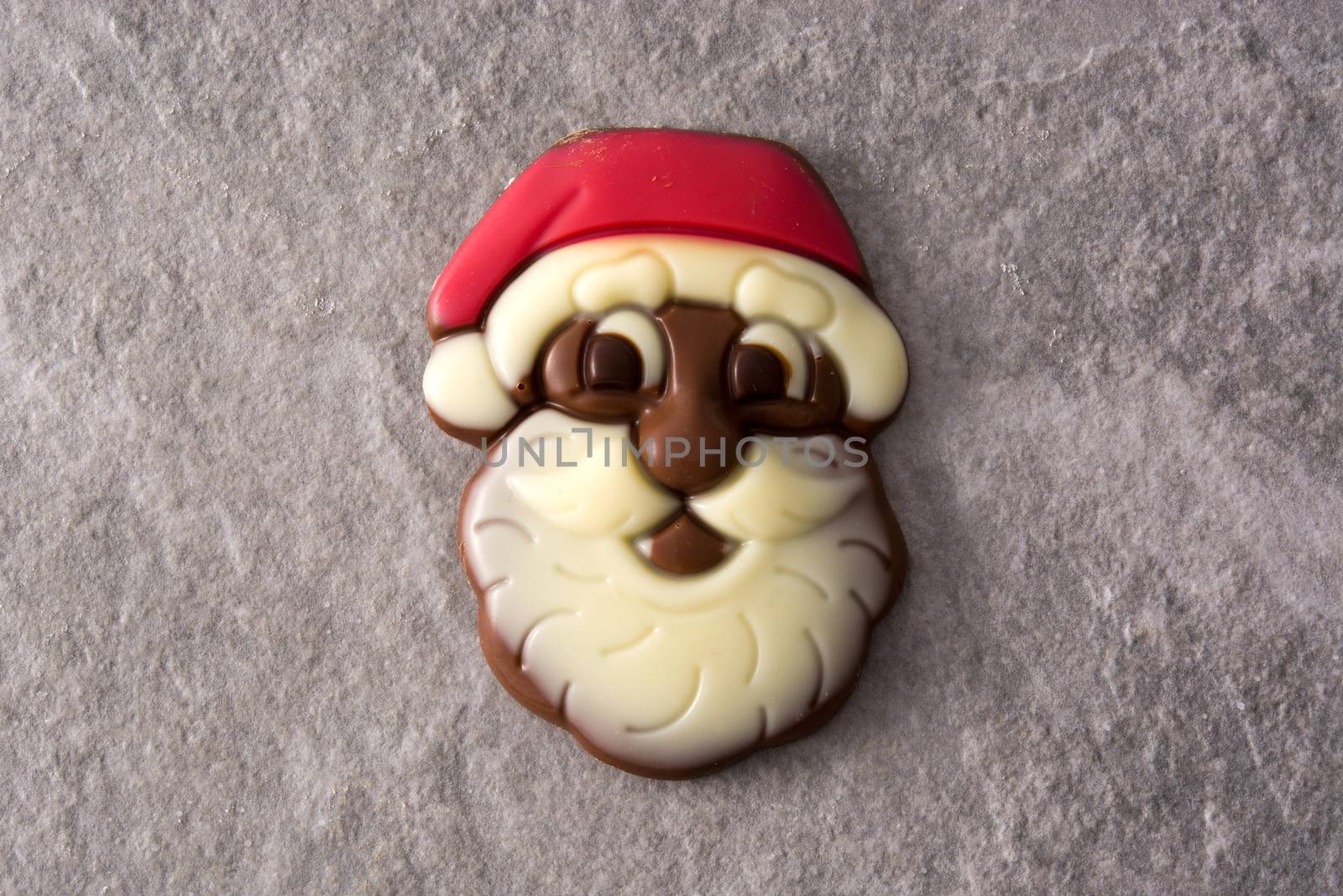 Christmas Santa Claus chocolate bonbon on gray stone background