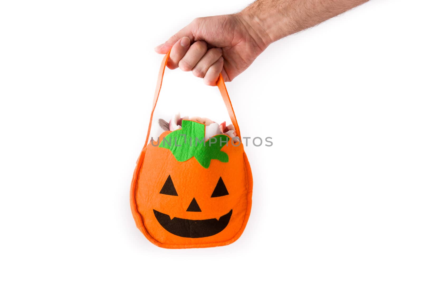 Hand holding Halloween pumpkin bag with candies inside by chandlervid85
