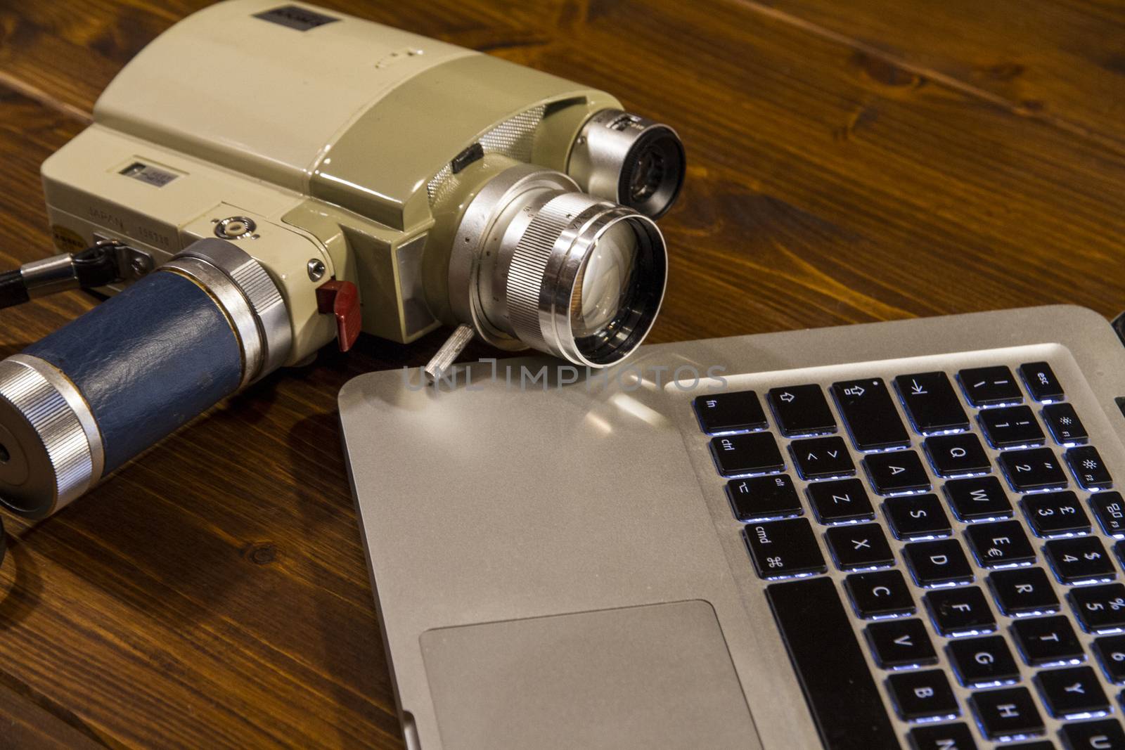 Contrast between different periods of technology: a vintage Super 8 cine camera from the 1960 with an actual computer laptop 