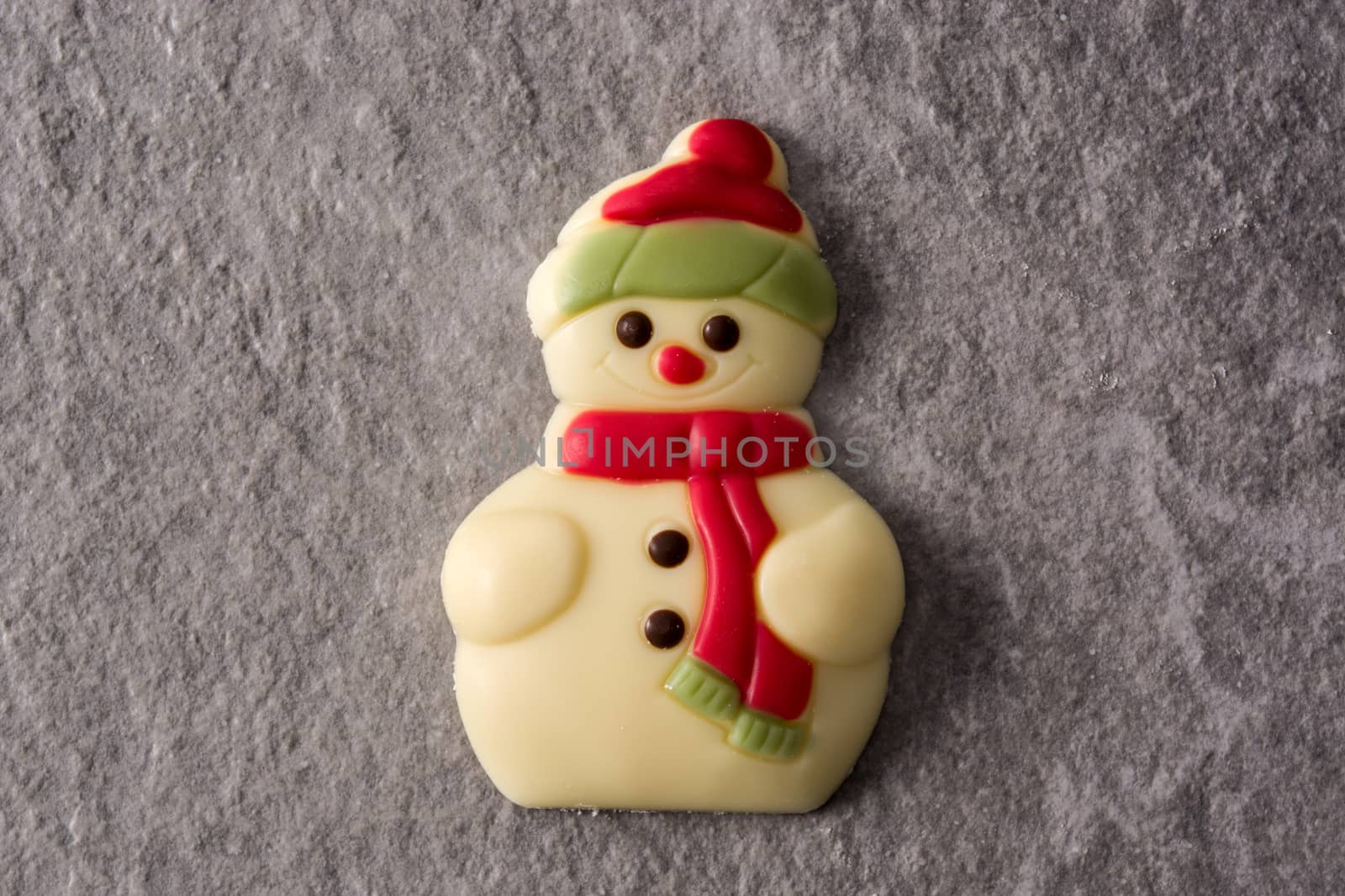 Snowman chocolate bonbon on gray stone background