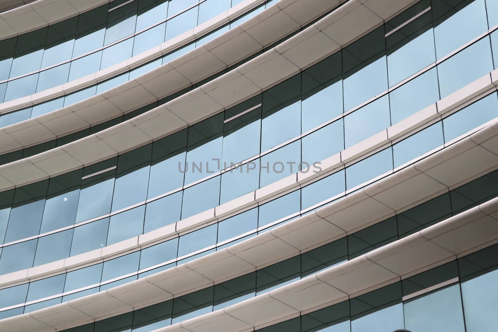 Curved glass front of the building with canopy.