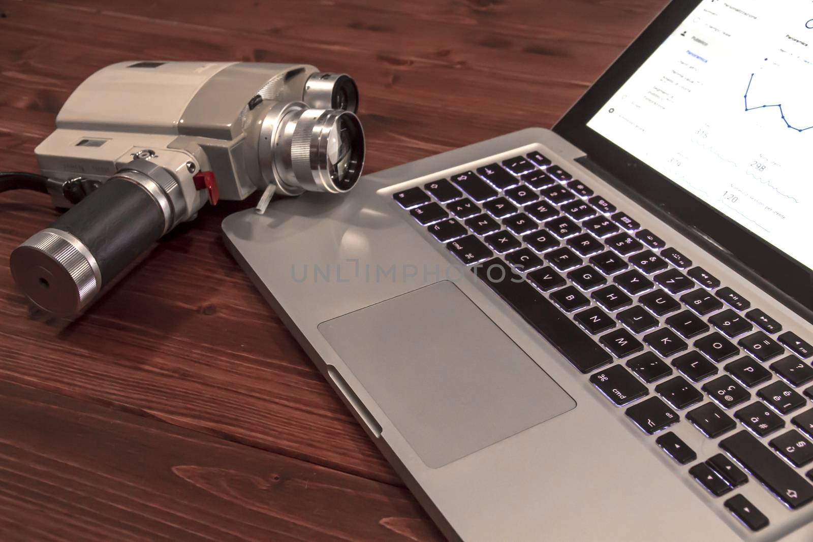 Contrast between different periods of technology: a vintage Super 8 cine camera from the 1960 with an actual computer laptop 