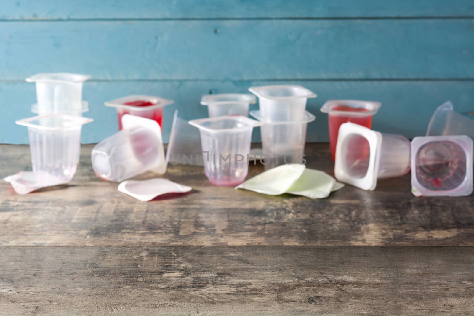 Empty plastic cups of jjellies on wooden background