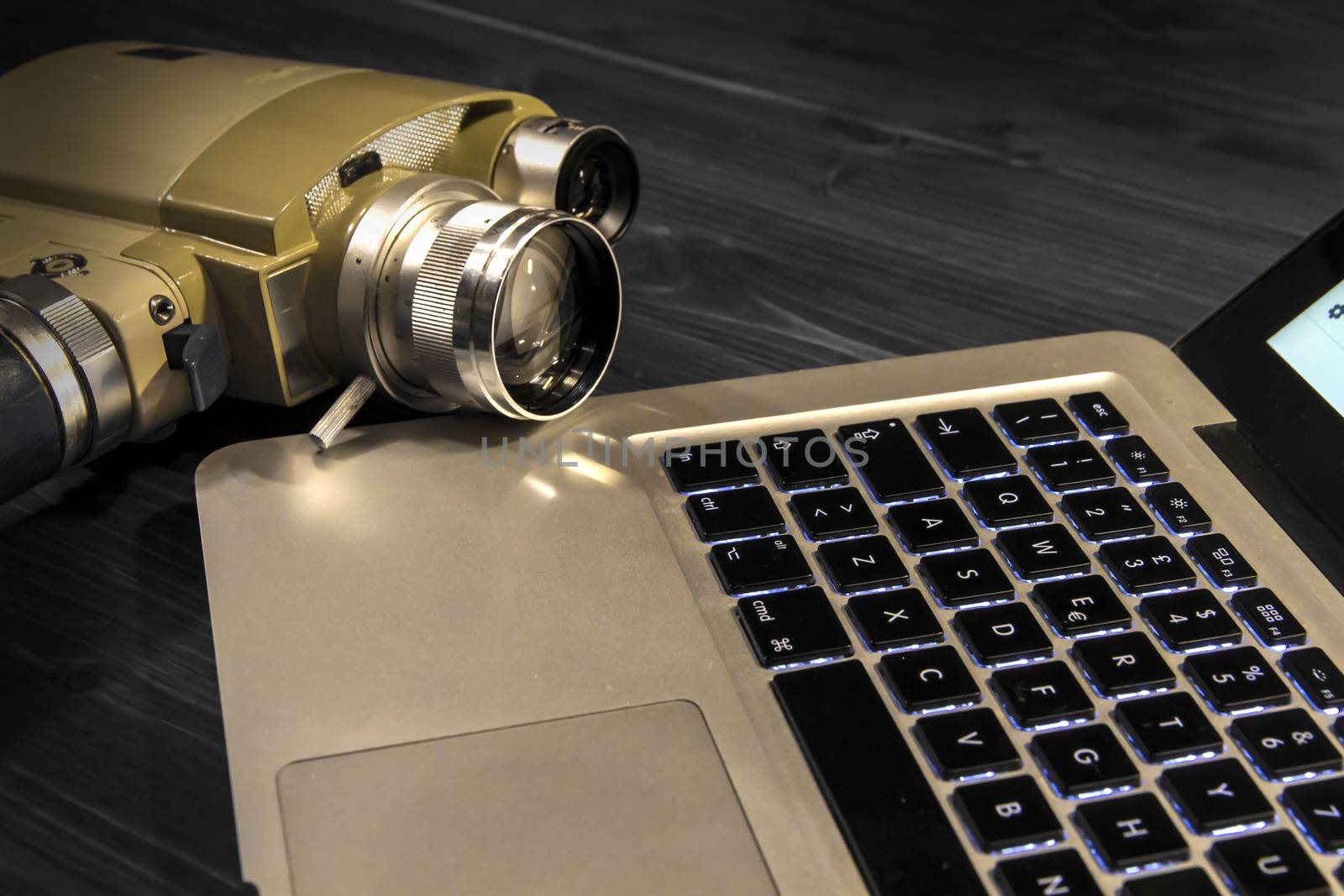 Contrast between different periods of technology: a vintage Super 8 cine camera from the 1960 with an actual computer laptop 