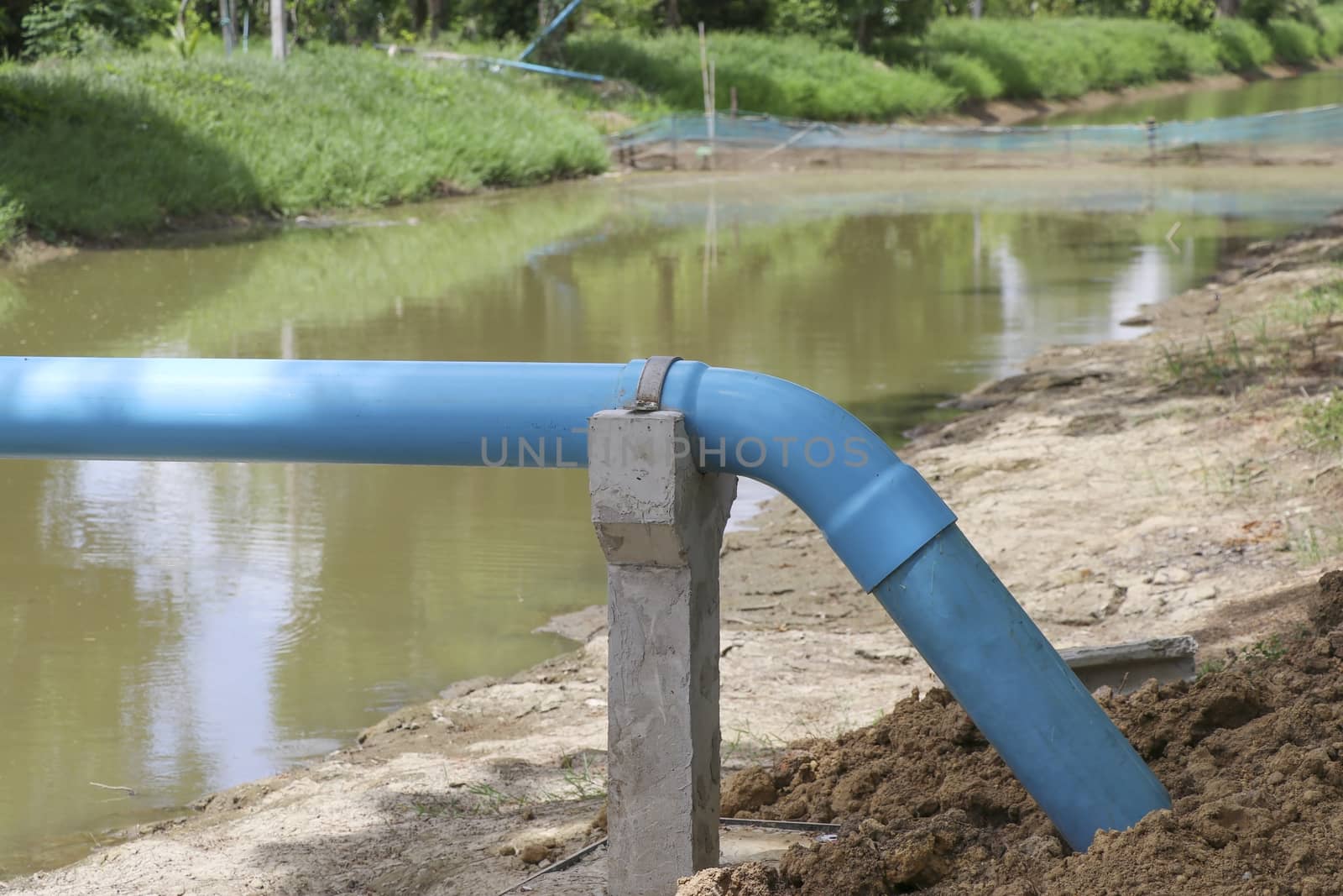 Blue water pipe with support concrete. Water pipeline for agriculture. by Eungsuwat