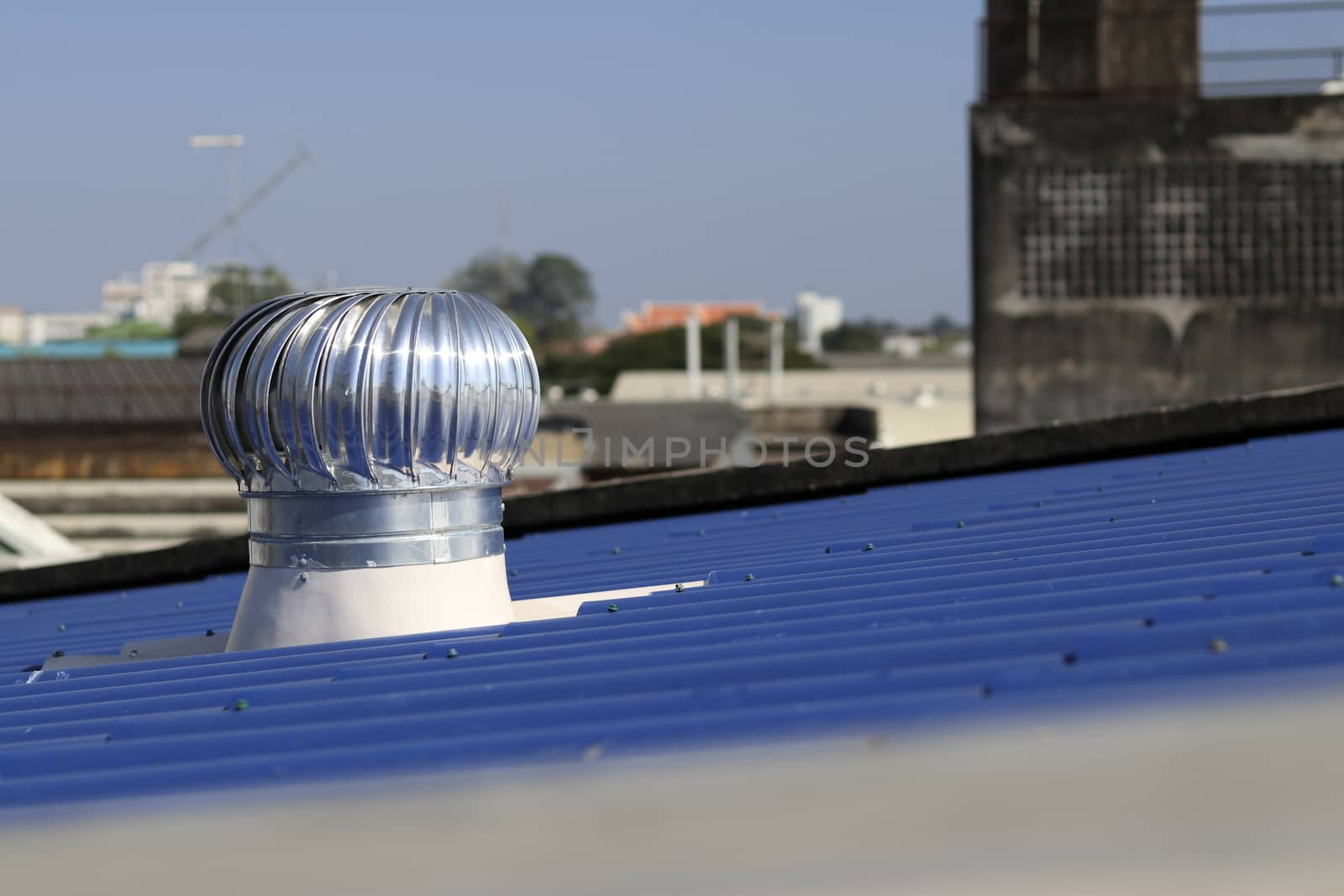 Turbine ventilator installed on the blue roof. Turbine ventilator helps the air to flow at all times.