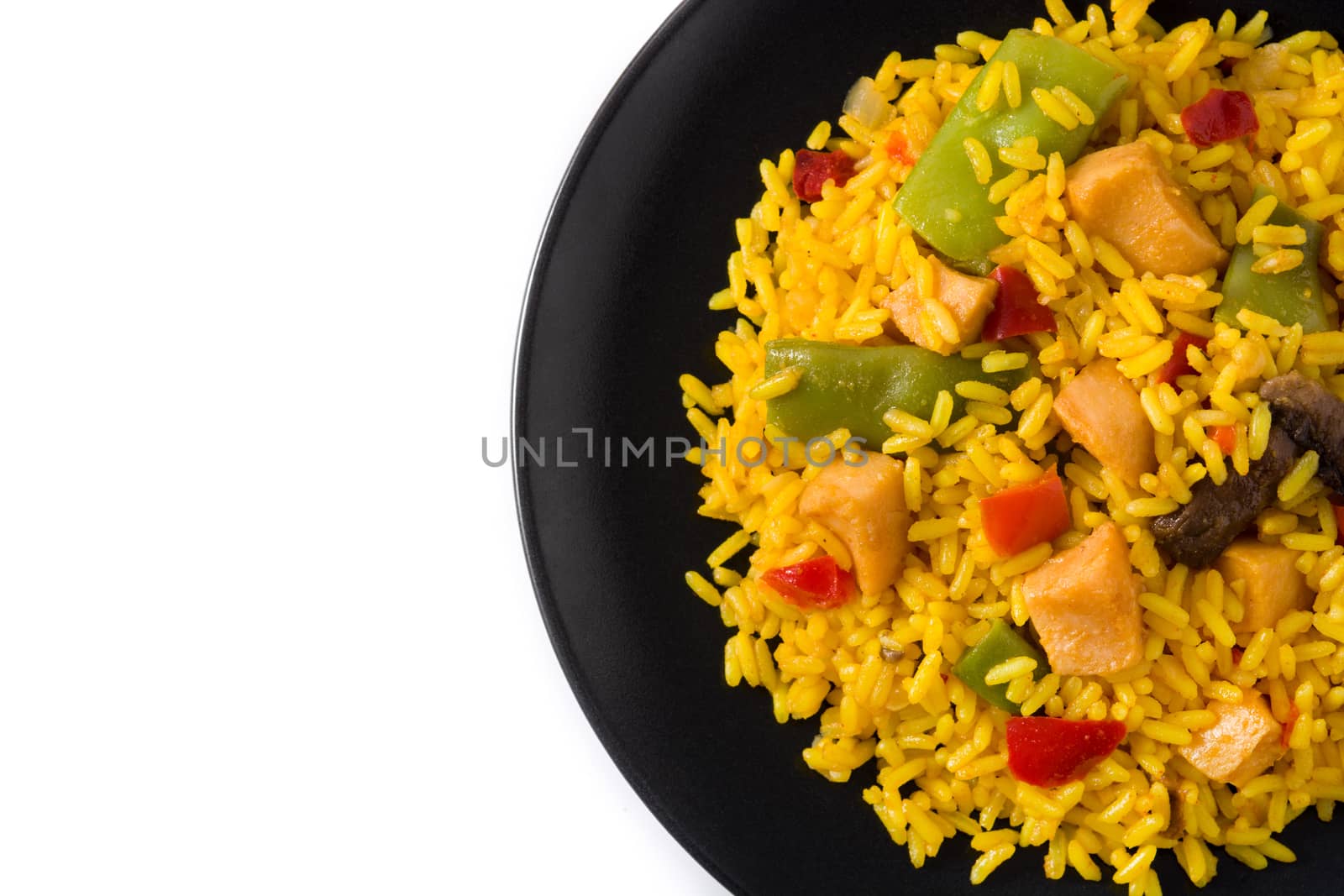 Fried rice with chicken and vegetables on black plate isolated on white background