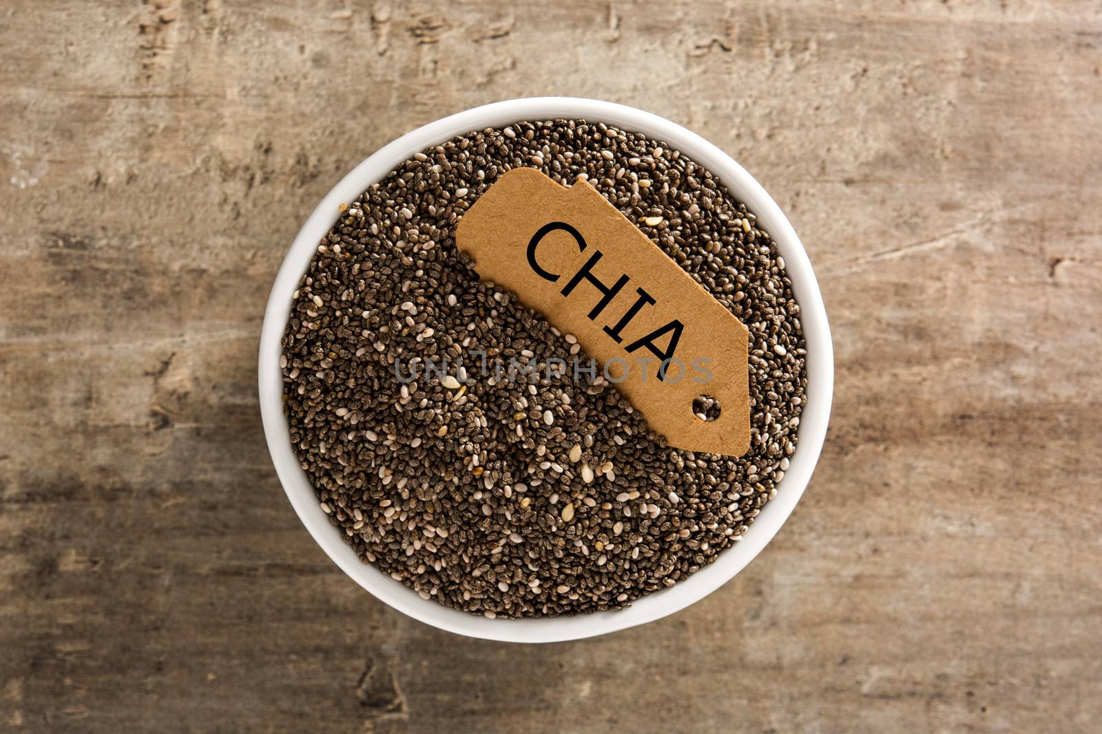 Chia seeds in bowl on wooden table