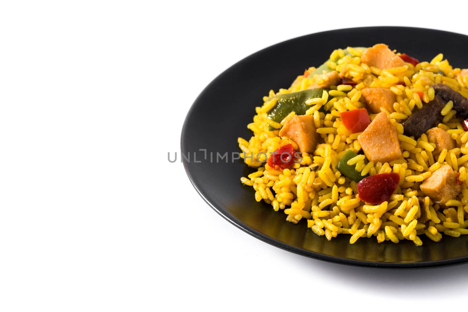 Fried rice with chicken and vegetables on black plate isolated on white background