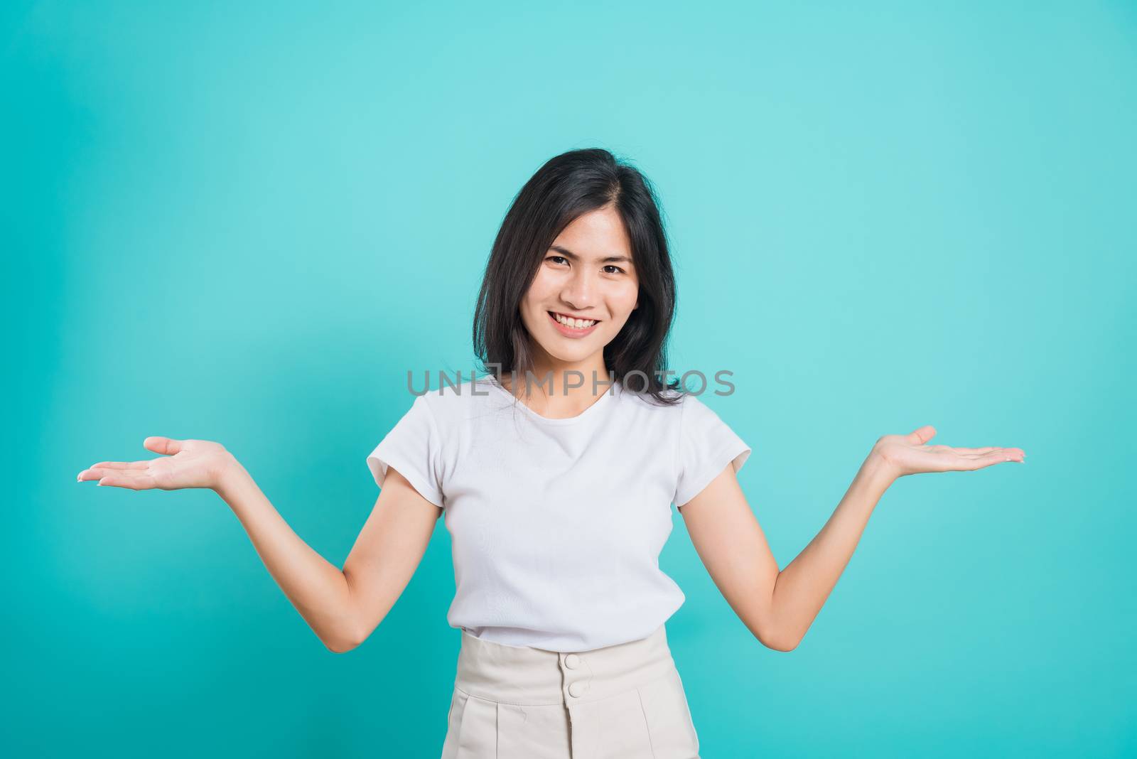 Young woman standing showing hand presenting product by Sorapop