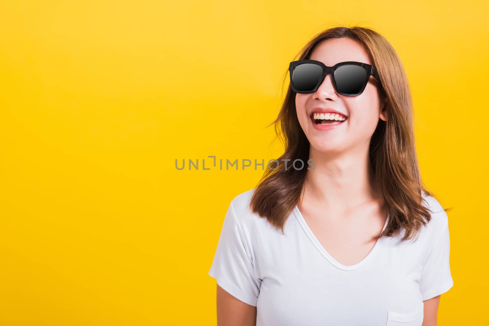 woman happy smiling white teeth with sunglasses and looking side by Sorapop