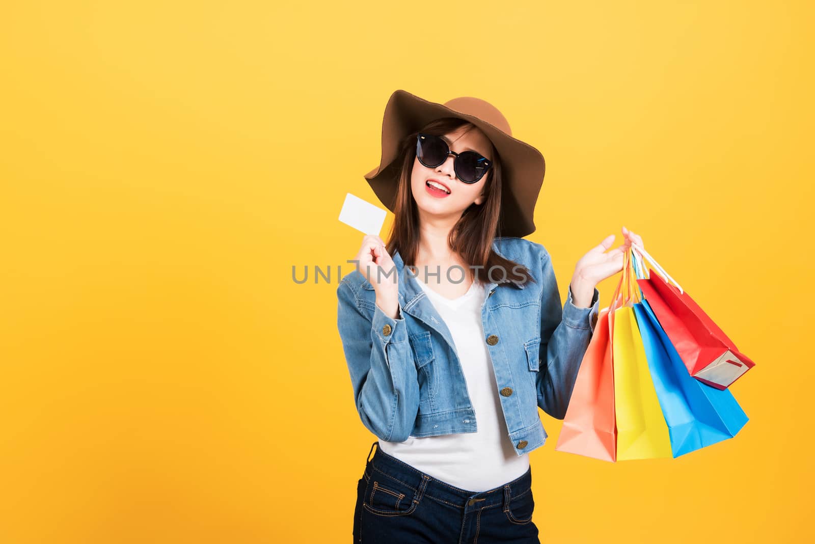 Young woman using credit card enjoys shopping by Sorapop