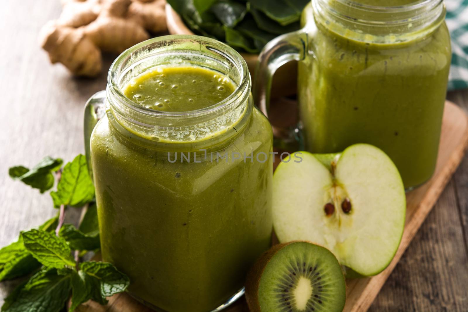 Healthy green smoothie in jar on wooden table