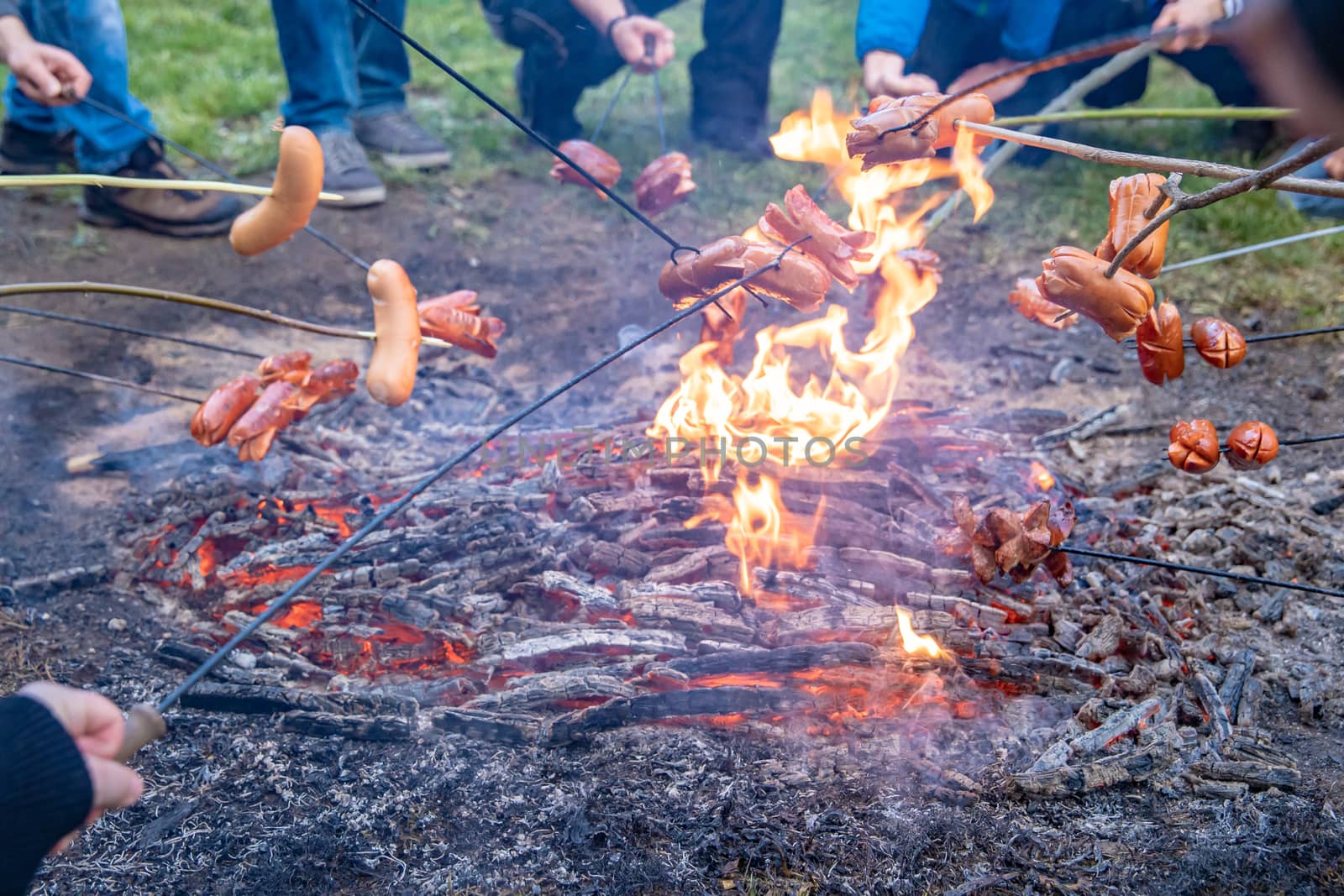 grilling sausages on an open fire with large family gatherings.