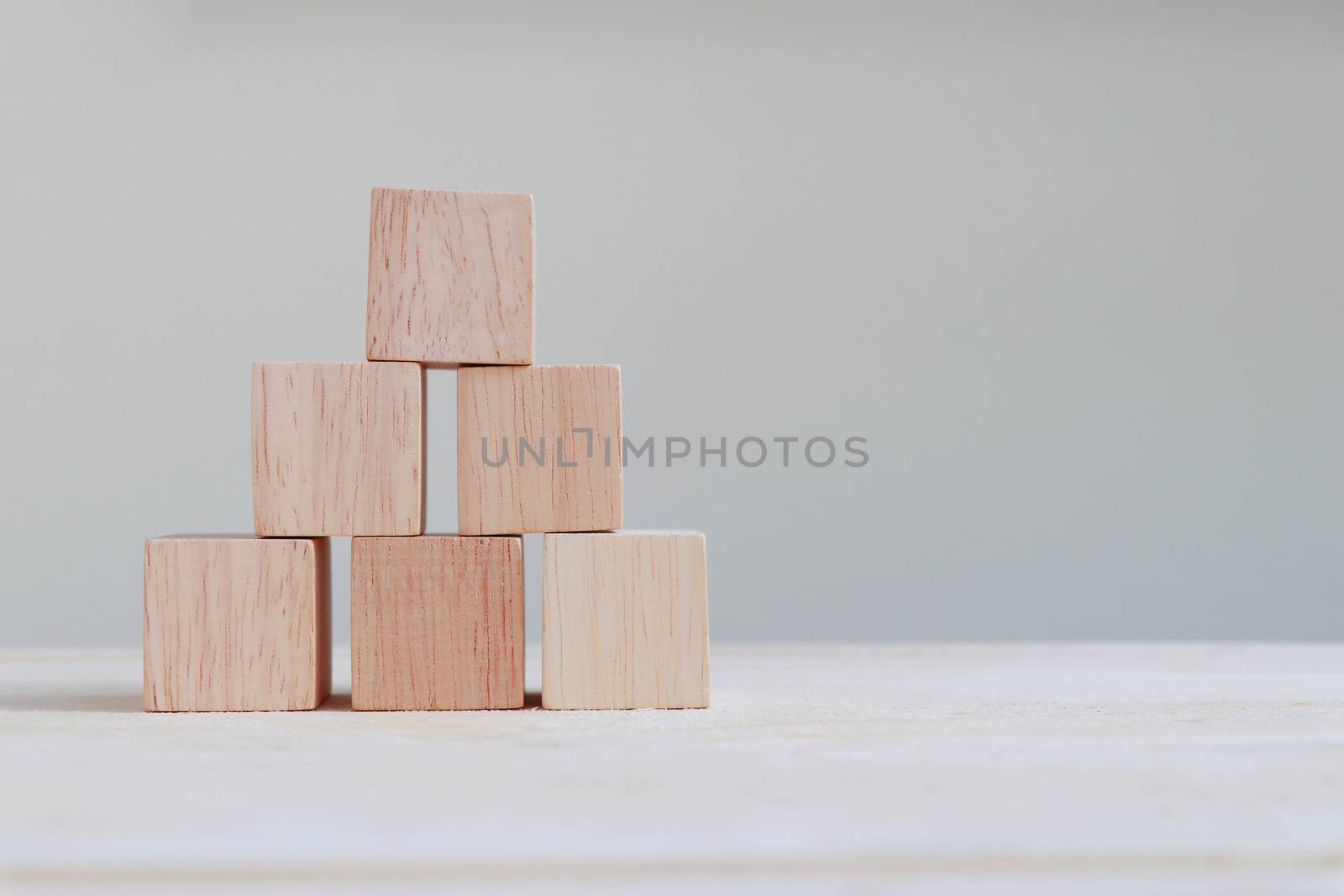 Wooden cube arranged in three layers with copy space on the right.